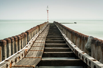 Sea pier with wooden poles and endless horizon of the sea - 750193469