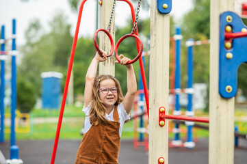 portrait of a happy smiling girl 6 years old playing on a children's playground.looks at the camera close-up. High quality photo