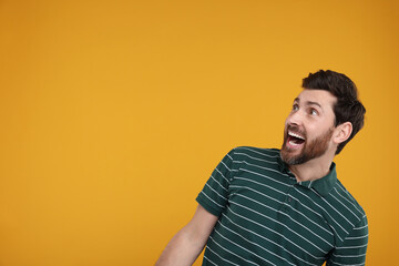 Portrait of surprised man on yellow background, space for text