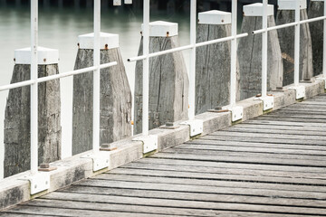 Balustrade of jetty in the port of Vlissingen. wooden poles with gangways in rhythmic composition - 750194813