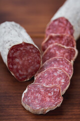 traditional Spanish salami fuet sausage or dry sausage cut in slices in a kitchen table.