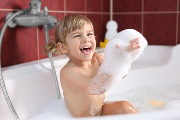 Happy girl having fun in bathtub at home