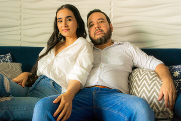 Colombian Latin couple sitting on a blue sofa