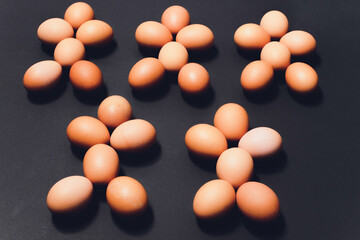 Many eggs lie together on each other, brown eggs, a lot of chicken eggs. in the shape of a man