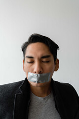 Latin man having tape over his mouth