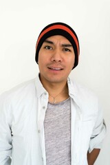 Latin man wearing a beanie on the white background making facial expressions