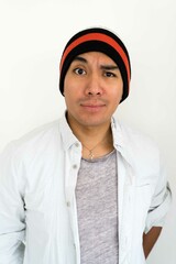 Latin man wearing a beanie on the white background making facial expressions