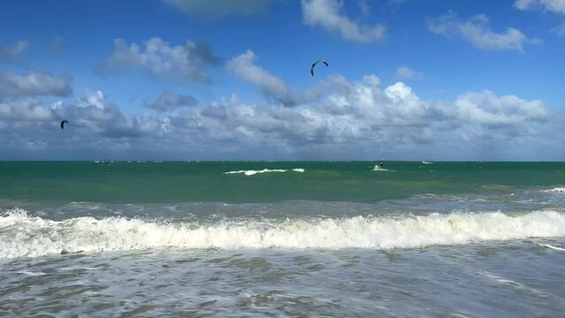 CUBA - DECEMBER 22: Kitesurfing in Varadero. Several people are kitesurfing on the beach on a cloudy day. Kites are lifted into the air by the wind. Tourists ride kiteboards in the turquoise ocean. 4К
