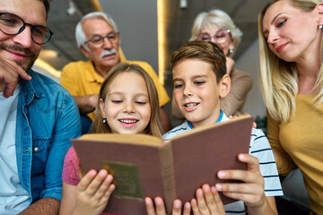 child family portrait woman mother man father grandmother daughter group reading book education girl grandparent generation female grandchild together senior grandfather son boy three