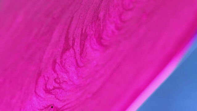 Vertical video. Color ink background. Sparkling paint. Bright fluid smooth texture effect pink flow spreading in abstract in hypnotic vibrant trendy design art.