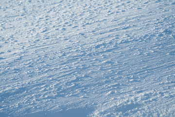 winter landscape, snow-covered field with snowdrifts against the blue sky