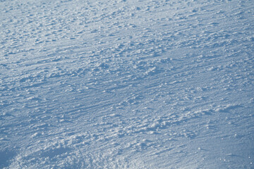 winter landscape, snow-covered field with snowdrifts against the blue sky