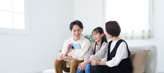 スマートフォンで動画を見る家族 © taka