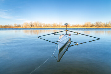 Coastal rowing shell by on a lake in northern Colorado in winter or early spring scenery.