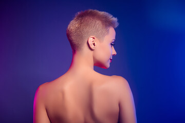 Back rear spine view photo of girl with blond bob hair look over vivid color empty space background