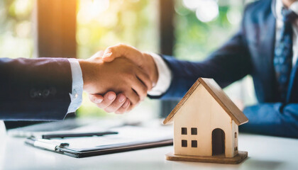 Business deal handshake over blurred wooden house on table, symbolizing agreement, partnership, real estate, success