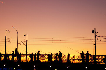 Bosphorus Twilight Anglers: Silhouetted Figures Fishing on Istanbul's Bridge at Sunset
