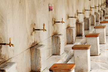 Spiritual Purity: Golden Faucets and Marble Ablution Area at the Blue Mosque, Istanbul, Turkey