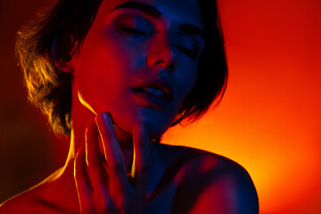 Photo of adorable pretty woman naked shoulders arm hand chin empty space isolated red neon color background