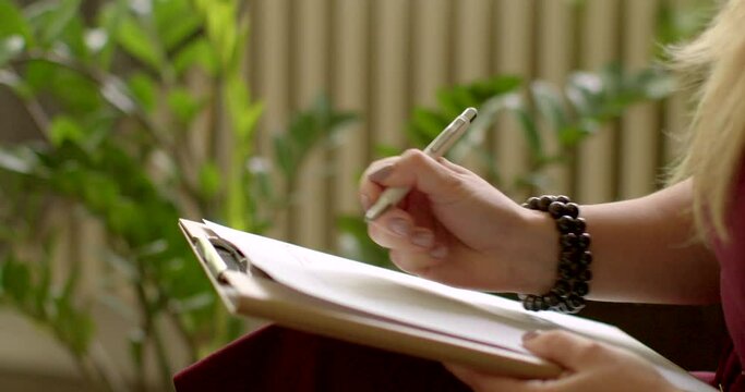 Psychotherapist takes notes about patient's condition on paper during session. Close-up of pen and paper. Makes written records of progress and insights during the therapy session. People lifestyle.