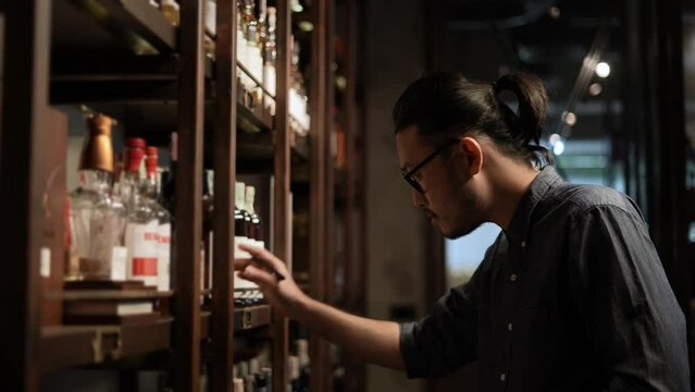 Night club concept of 4k Resolution. The bartender is checking the merchandise in the store. A group of specialized clubs that sell alcoholic beverages.