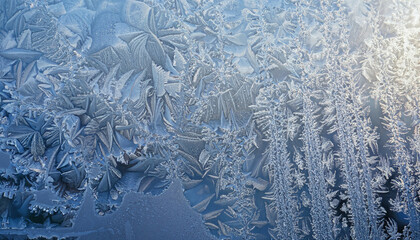 Beautiful frost pattern on a winter window; abstract background and textured image