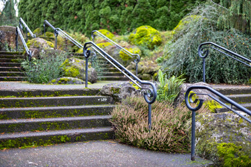 Stone steps with metal railings, metal handrail design, stairs in a park or protected area with green forest plants