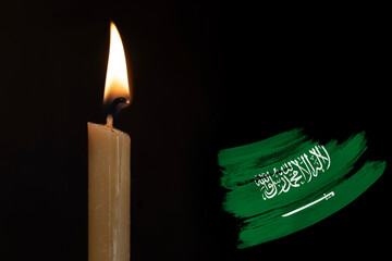 mourning candle burning front of flag Saudi Arabia, text Arabic testify there no other God but...