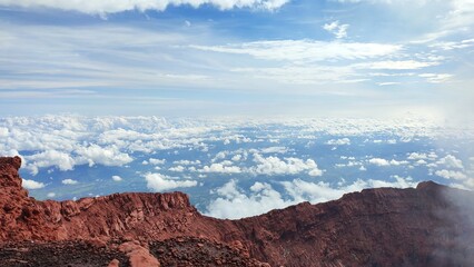 Clouds are visible in the blue sky above the volcanic peak of Mount Kerinci in Indonesia