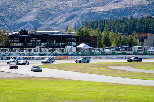 Cromwell , New Zealand- 2 March, 2024: Competitive drivers navigate the turns at Cromwell Highlands Motorsport Park during a national endurance racing event, with the scenic highlands as a backdrop.