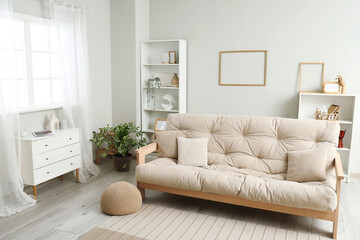 Interior of light living room with white commode and sofa