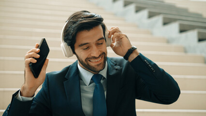 Closeup of smart business man listening and enjoy music while wear headphone. Project manager...