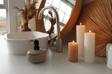 Burning candles with soap near sink in bathroom, closeup