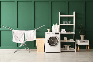 Interior of room with laundry basket, dryer and washing machine