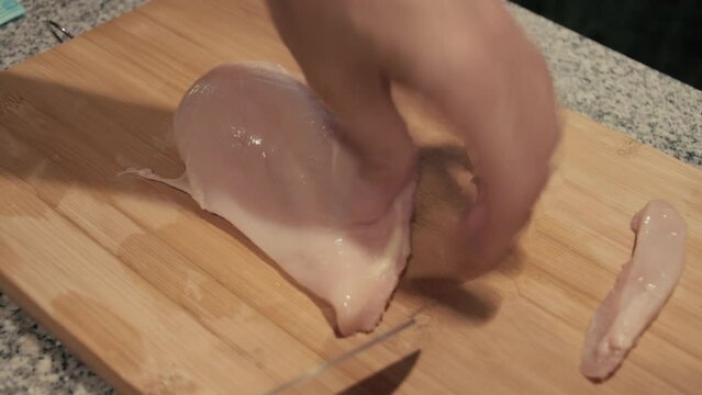 March 3, 2024 - Toronto, Ontario Canada. Close up demonstration on two ways to slice a chicken breast for wraps, pasta or other dishes.