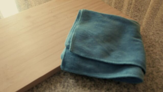 March 3, 2024 - Toronto, Ontario Canada. Inspecting a wooden chopping board and rag on a counter.