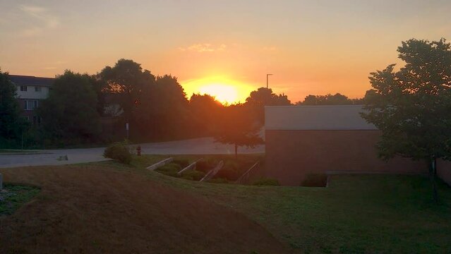 July 4, 2020 - Cambridge, Ontario Canada, The sun rises behind a school on a hot summer morning.