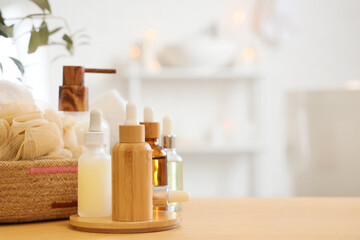 Fototapeta na wymiar Cosmetic dropper bottles with loofah on table in bathroom, closeup