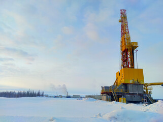 Oil drilling rig. Winter at dawn in the snow