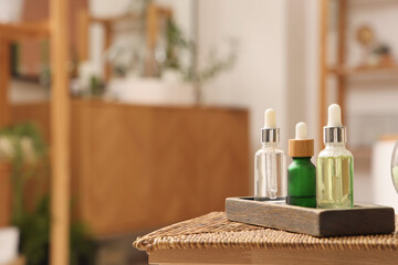 Cosmetic dropper bottles on table in bathroom, closeup