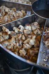 Pieces of pork knuckle in a meatball boiler