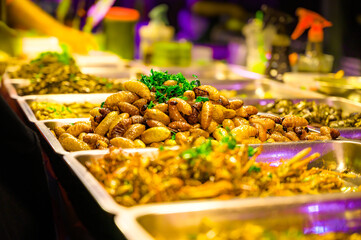 Fried red palm weevil with salt and pepper on a food stall