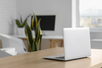 Modern laptop on desk in office, closeup