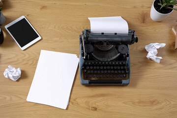 Vintage typewriter with paper sheets on wooden table, top view