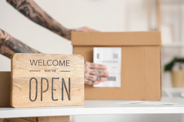 OPEN sign on seller's table in warehouse, closeup
