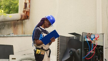 Proficient expert servicing outdoor air conditioner internal components, checking refrigerant level...