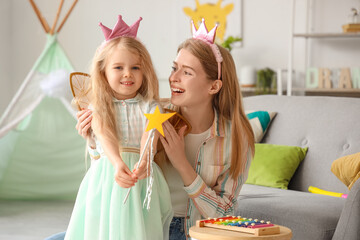 Cute little girl dressed as fairy with her mother at home