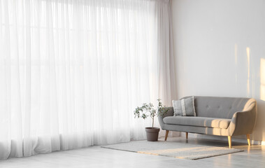 Interior of living room with light curtain and sofa