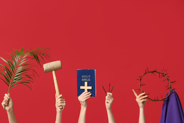 Female hands with crown of thorns, Holy Bible, palm leaf and nails on red background. Good Friday...