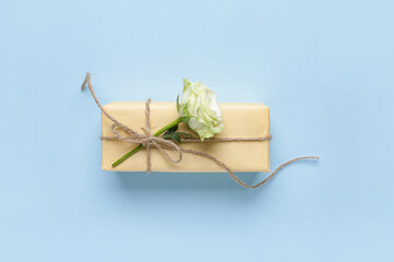 Fototapeta na wymiar Gift box with beautiful white rose on blue background. International Women's Day